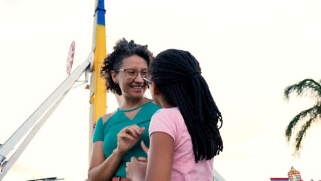 Mujer-Y-Niña-Hablando-En-El-Parque-De-Atracciones